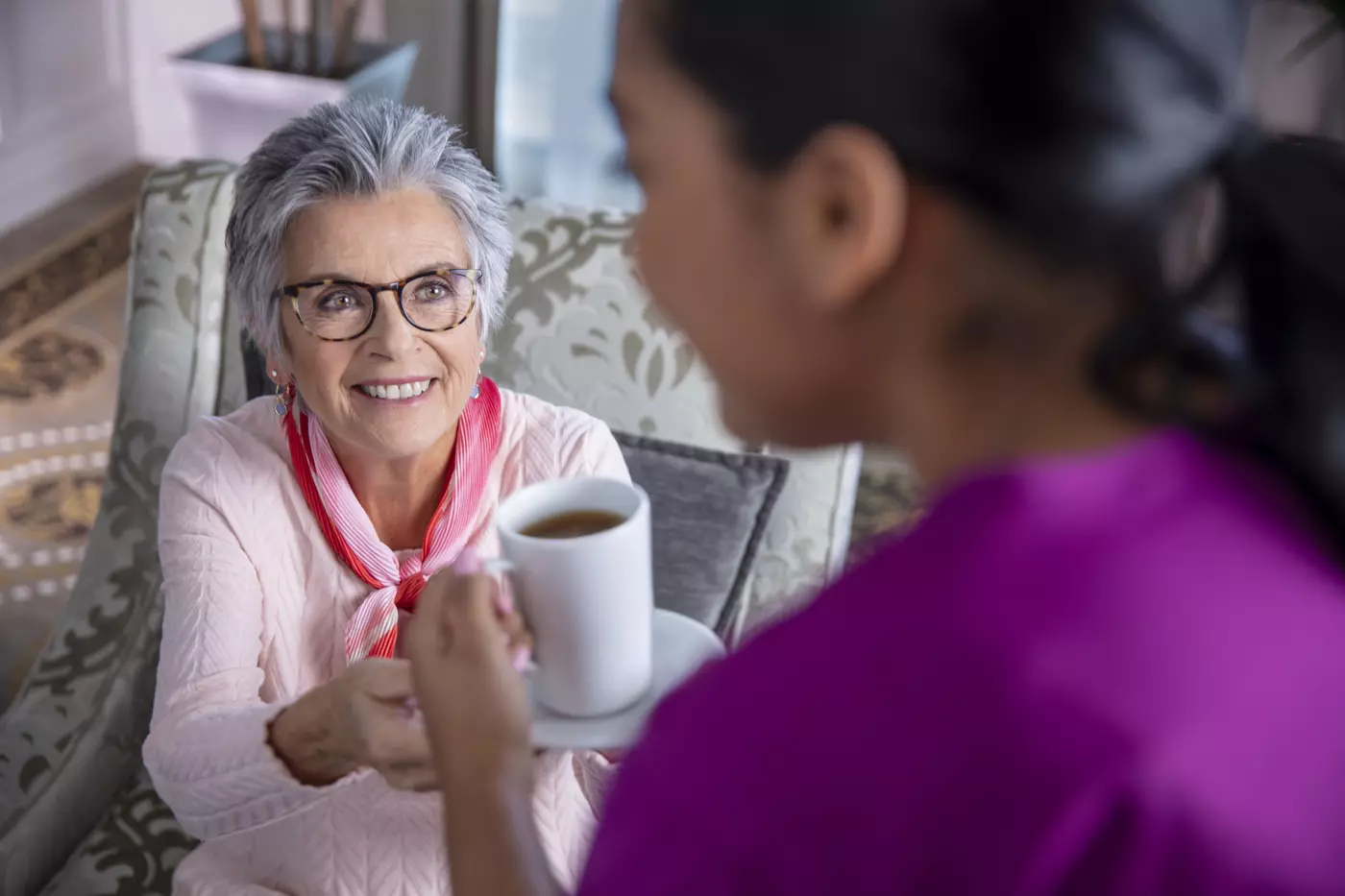 Chartwell care support staff serving coffee to a senior resident