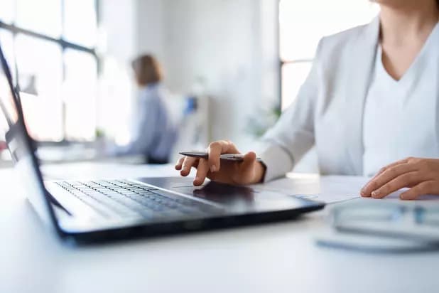 employee at desk, laptop,  woman in suit, office