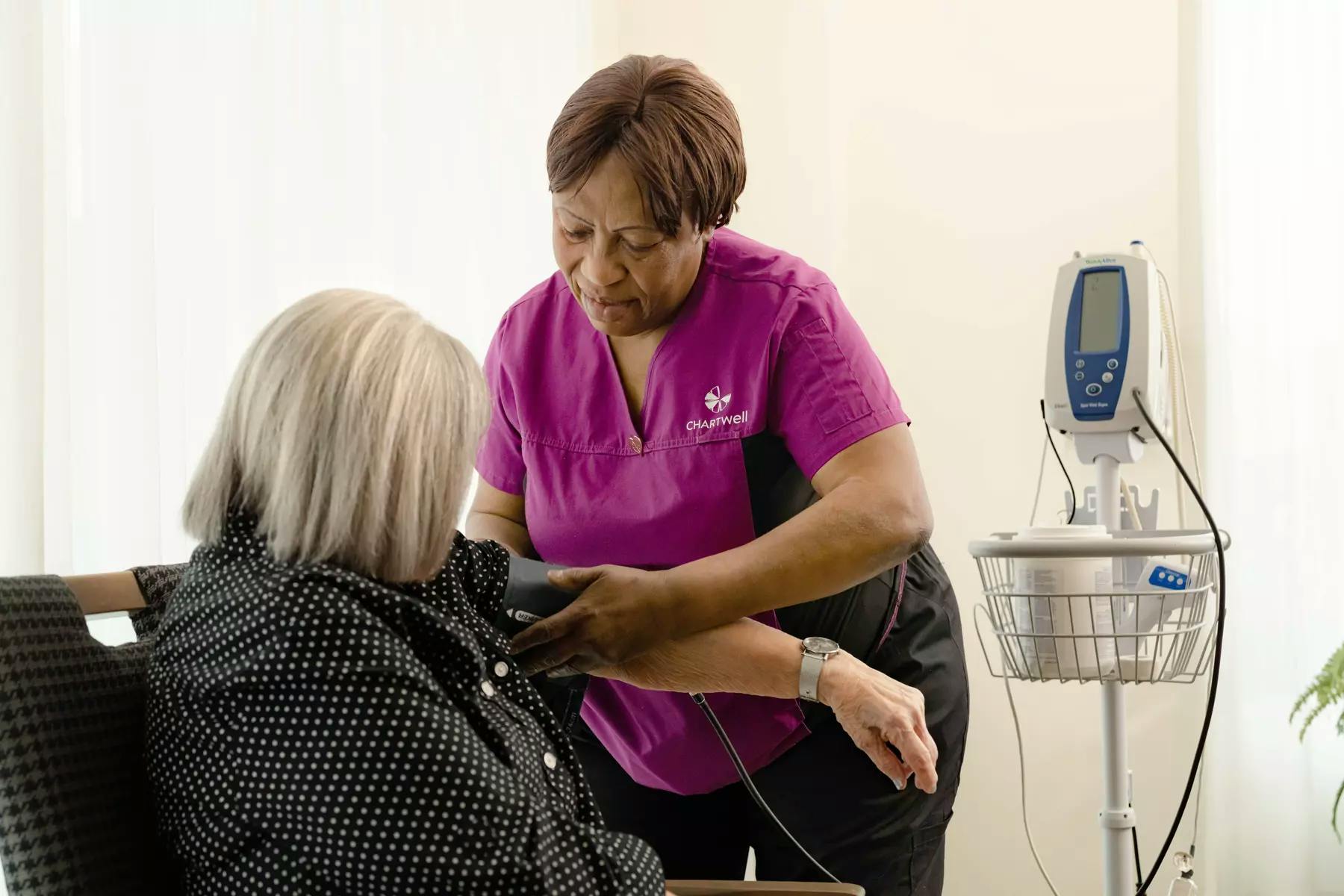 Chartwell Care staff measuring blood pressure of a senior resident