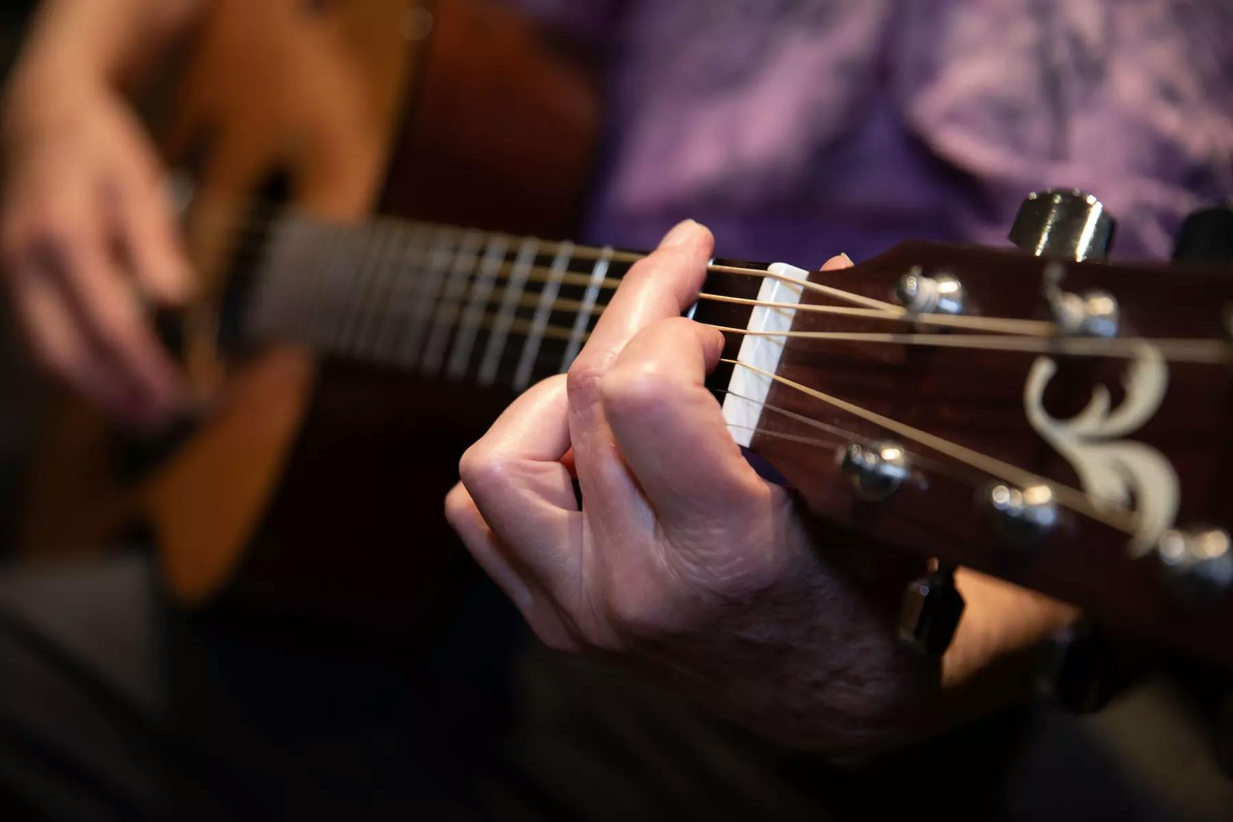 Close up of a person playing a guitar / Gros plan d'une personne jouant de la guitare