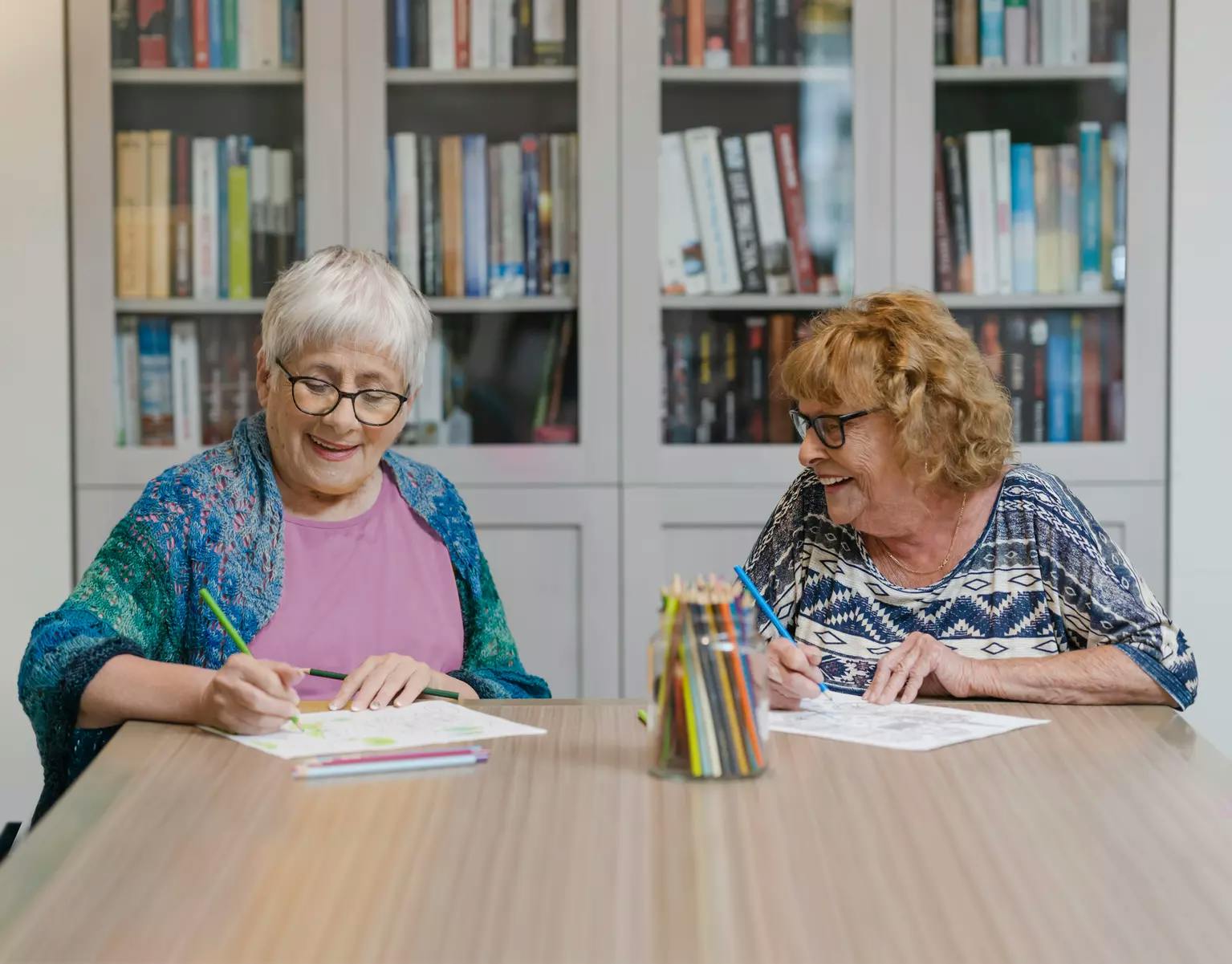 Two senior woman colouring with pencil crayons